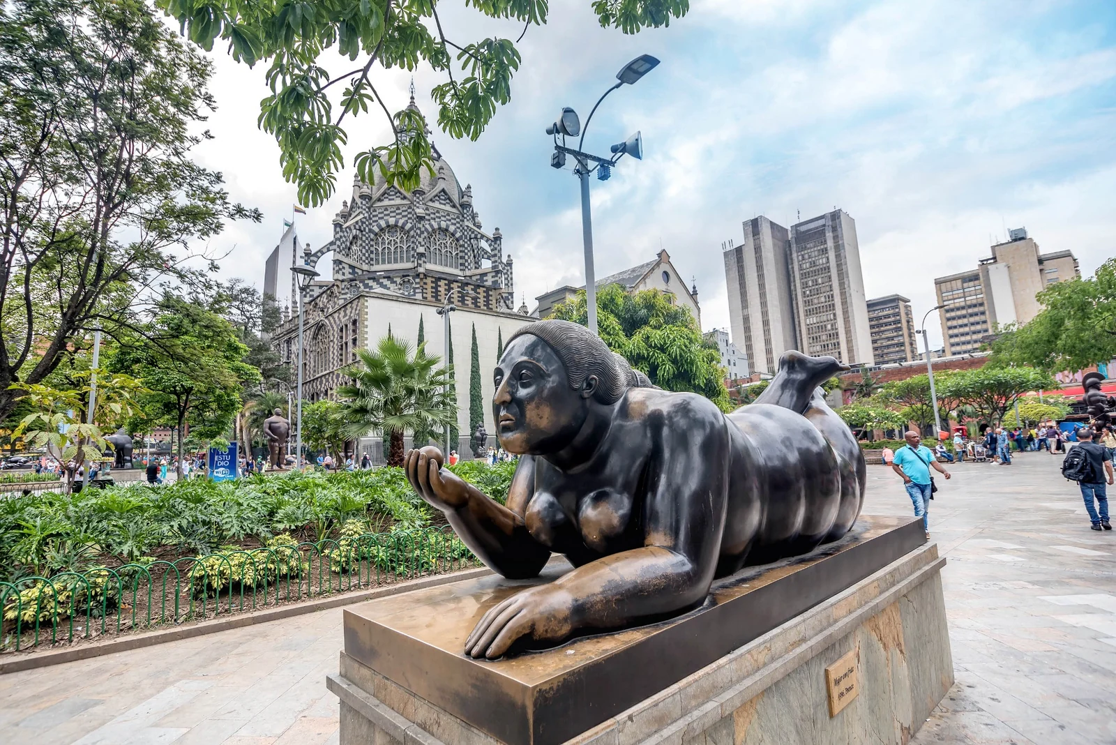 Escultura urbana en el centro de Medellín, con arquitectura histórica, edificios y espacio público al fondo.